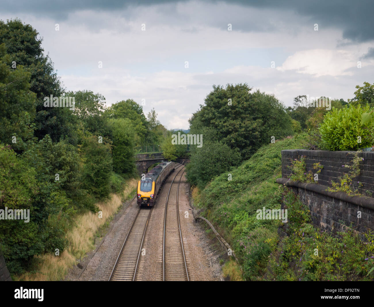 Fast moving train traveling down the train tracks in Belper, Derbyshire, United Kingdom. Stock Photo