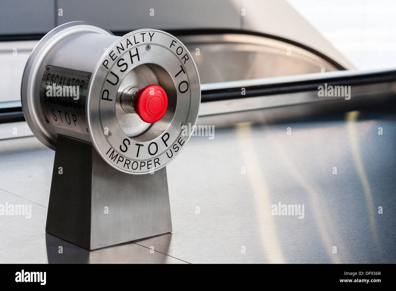 Red stop button at the top of modern train station escalators. Stock Photo