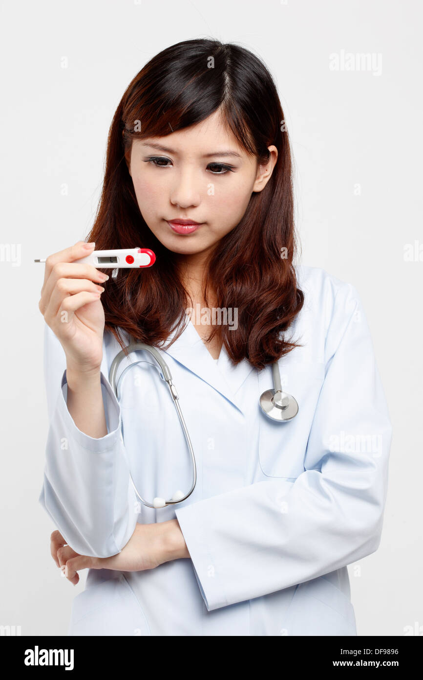 Female doctor looks at thermometer Stock Photo Alamy
