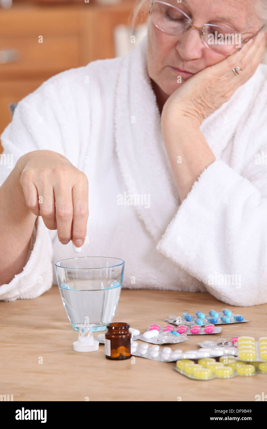 An old lady taking pills. Stock Photo