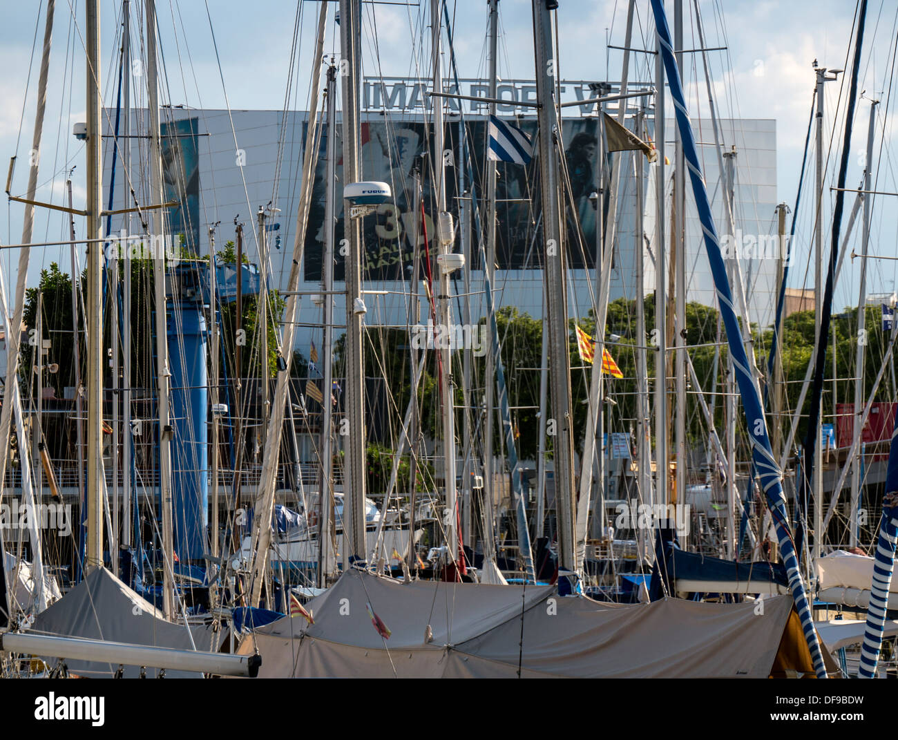 BARCELONA, SPAIN - SEPTEMBER 12, 2013:  The Marina at Port Vell with the Maremagnum Complex seen through the masts Stock Photo