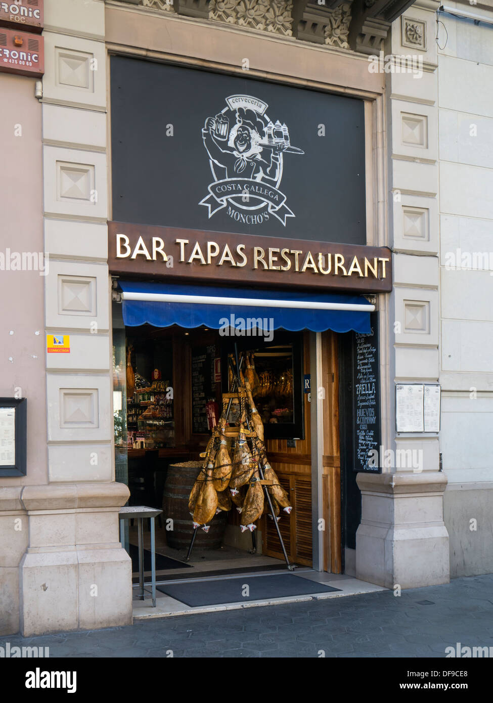 BARCELONA, SPAIN - SEPTEMBER 12, 2013: Hams hanging in entrance to Tapas Bar Restaurant in the Eixample Quarter Stock Photo