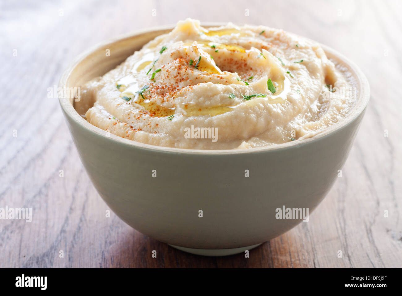 Delicious bowl of chickpea hummus with breadsticks Stock Photo