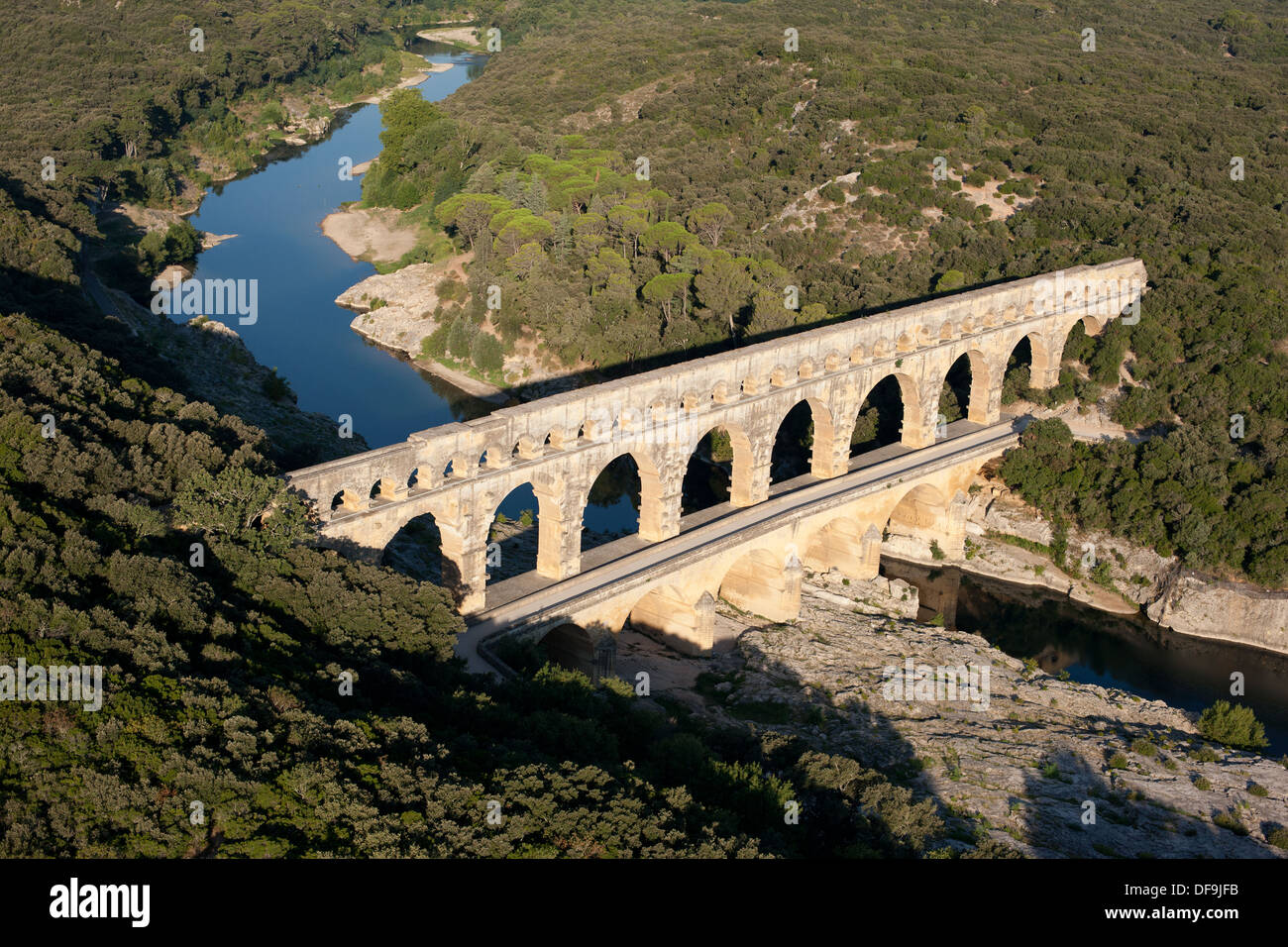 AERIAL VIEW. Roman aqueduct bridge over the Gard (aka Gardon) River. On the UNESCO world heritage list. Pont du Gard, Occitanie, France. Stock Photo