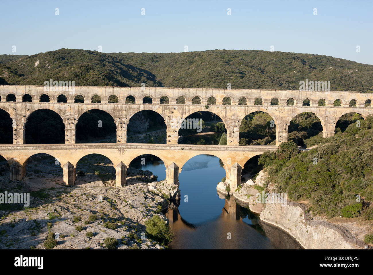 AERIAL VIEW. Roman aqueduct bridge over the Gard (aka Gardon) River. On the UNESCO world heritage list. Pont du Gard, Occitanie, France. Stock Photo