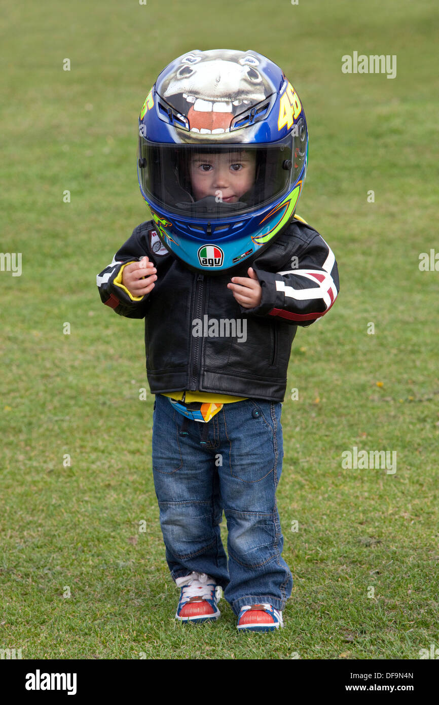 A young boy in his motorcycle gear, having come to a bikers meeting in