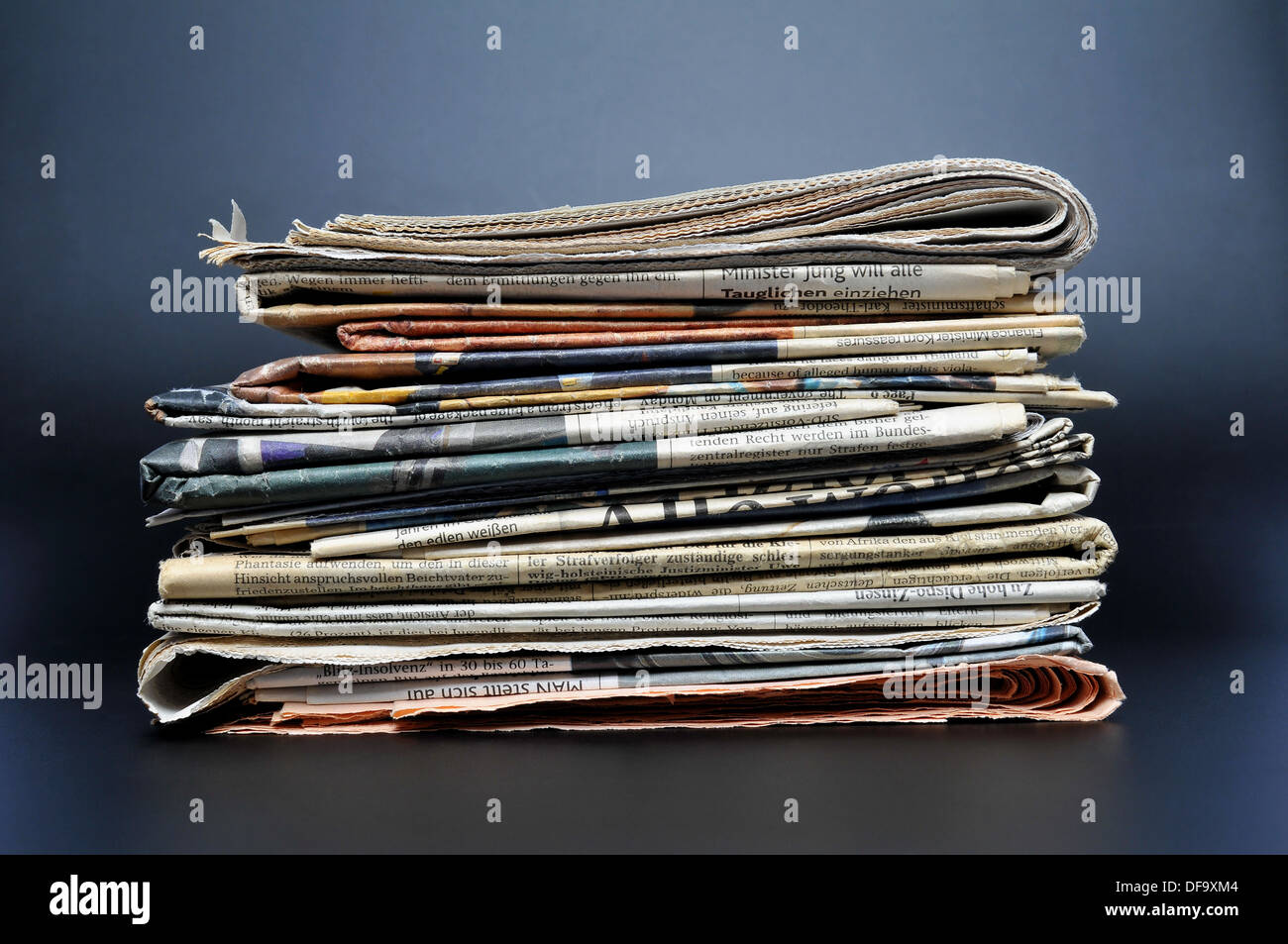 Stack of newspapers on black background Stock Photo