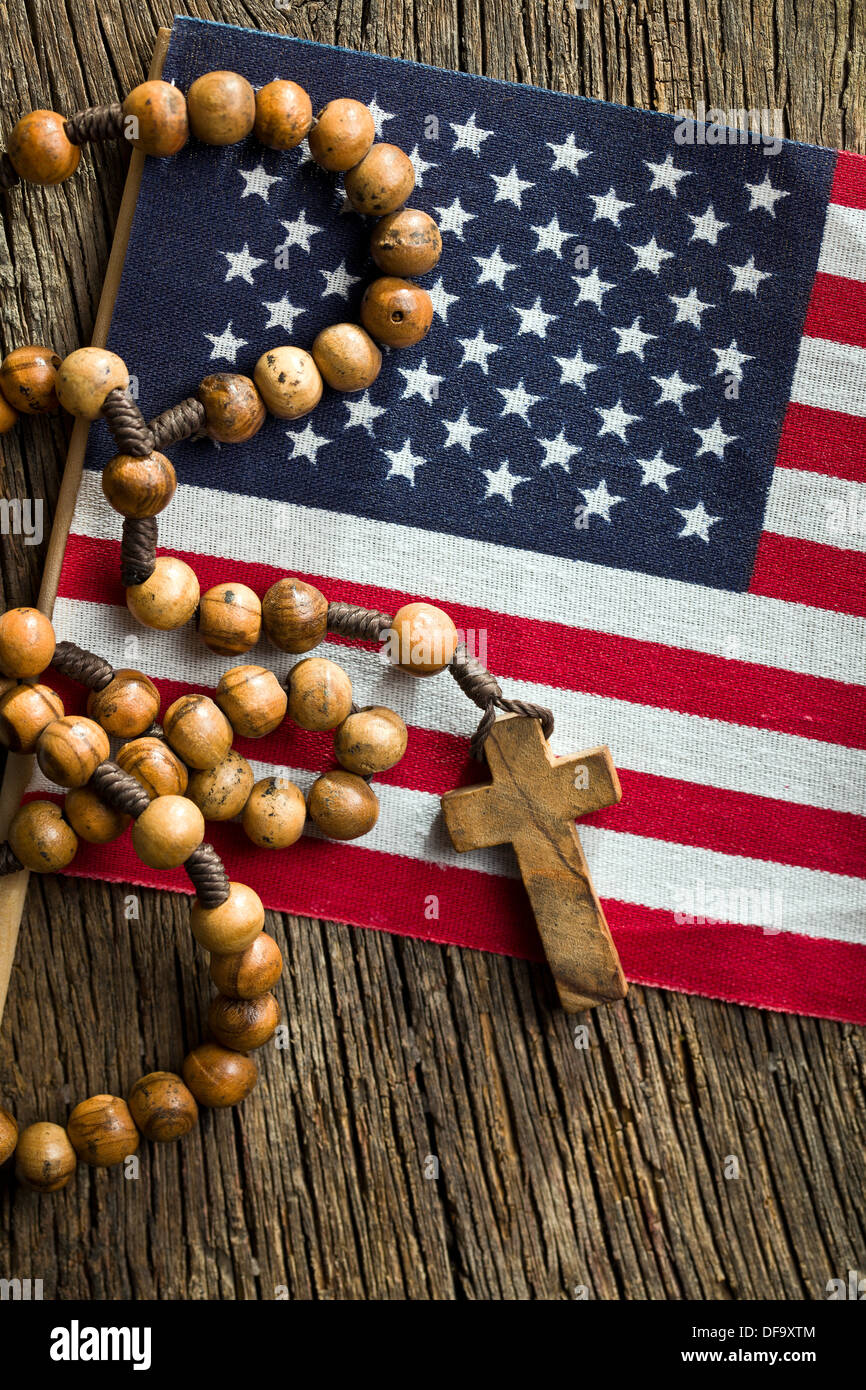 top view of rosary beads with american flag on wooden background Stock Photo