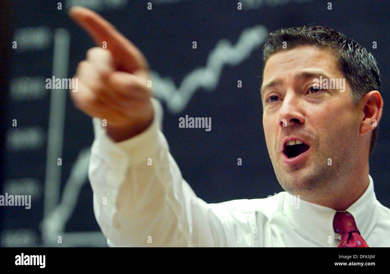 A broker points upwards standing in front of the display board for the German stock index (DAX) on the exchange floor of the stock exchange in Frankfurt on the Main on 03 November 2003. Stock Photo