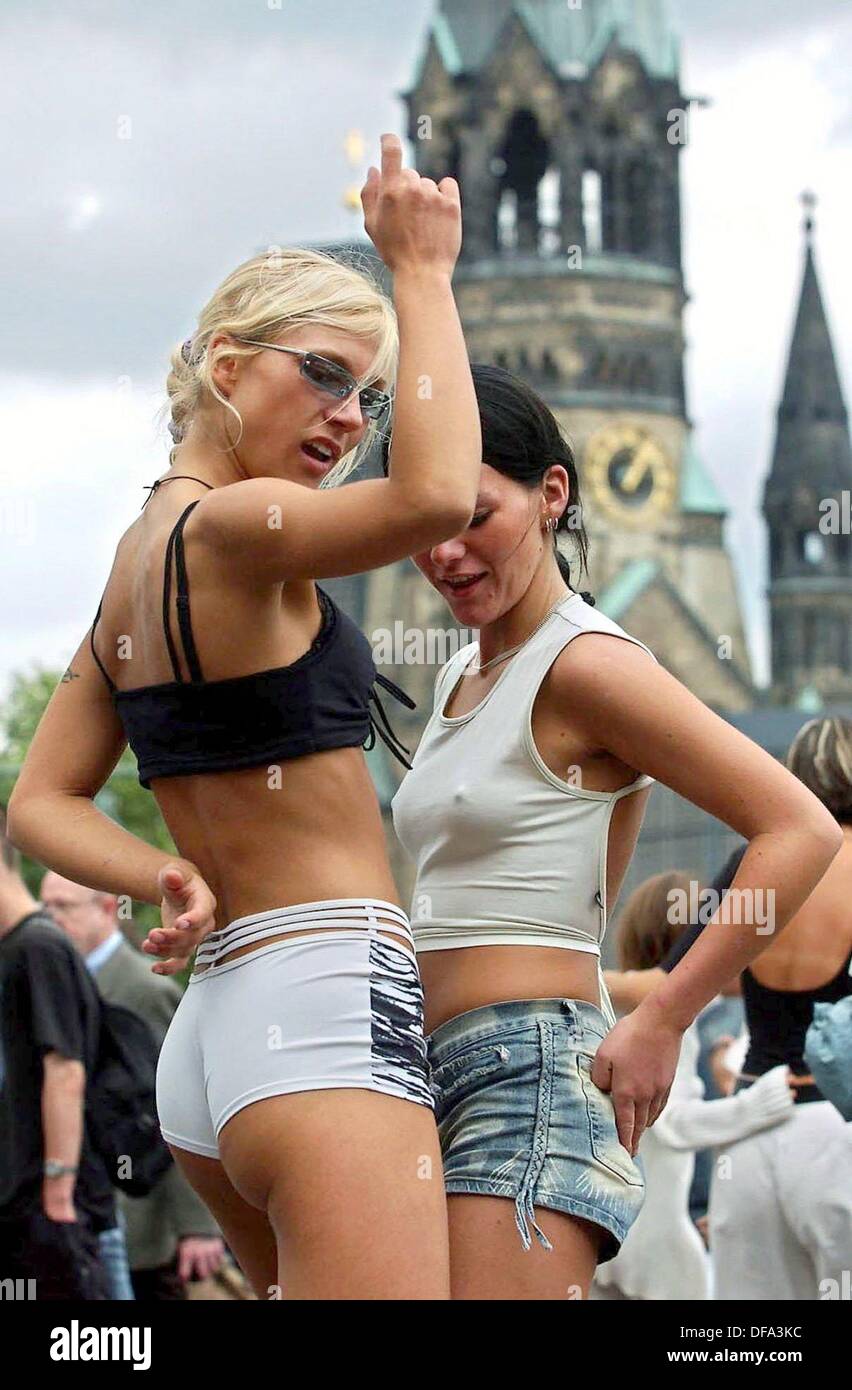 (dpa) - Two techno fans dance in front of the memorial church waiting for the 15th annual Love Parade to beginn in Berlin, Germany, 12 July 2003. Half a million scantily clad ravers danced through the heart of Berlin to the throbbing beat of the Love Parade, billed as the world's biggest techno dance party. Pulsing music from 26 sound trucks reverberated as the parade of writhing bodies made its way along the broad boulevard through the Tiergarten park between two Berlin landmarks - Brandenburg Gate in the east, and the 1870 Victory Column in the west. In peak years 1.5 million ravers danced t Stock Photo