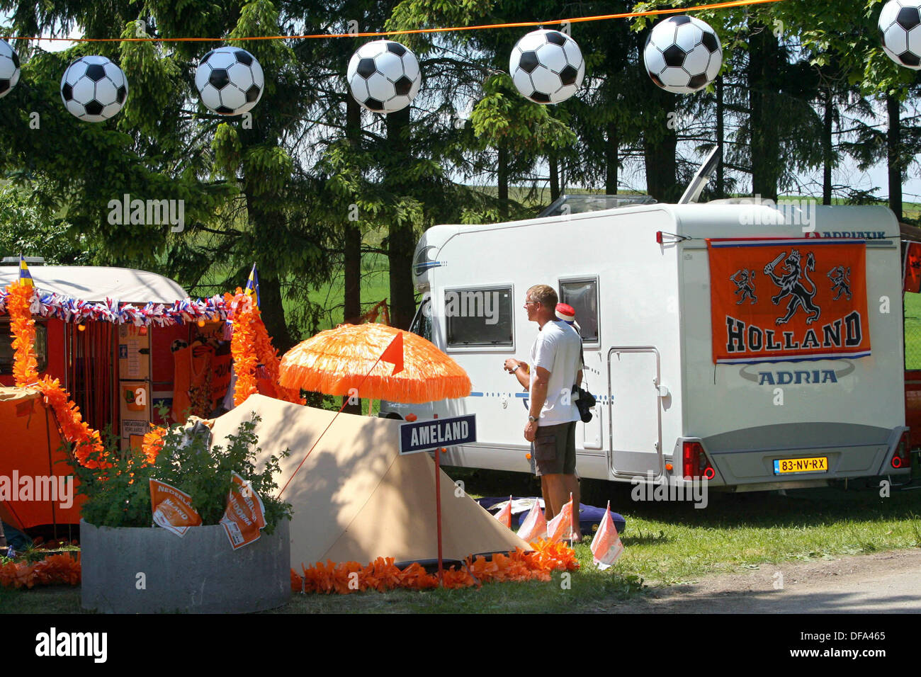 Two Dutch soccer fans stand in front of the camper at a camping ground. Up to 1,500 Dutch soccer fans accompany their team to Germany to watch the matches of the soccer world championship 2006. Stock Photo