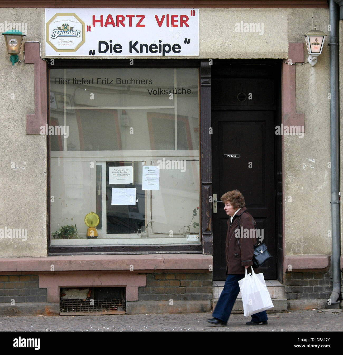A woman walks past a bar called 'Hartz Vier' near the employment agency in Leipzig. The name alludes to the job market reform 'Hartz Vier'. Stock Photo