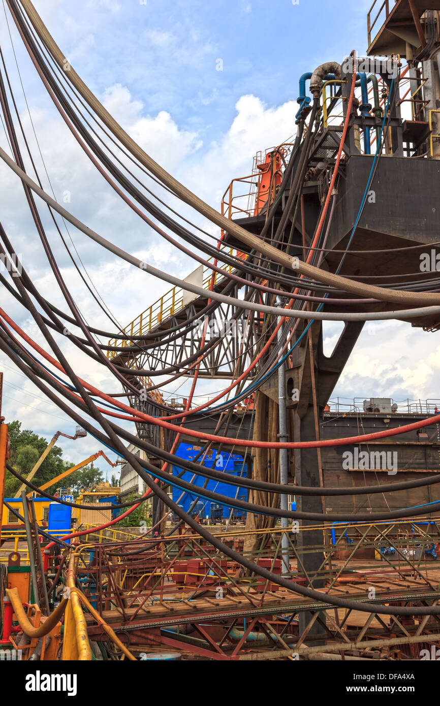 Many hoses of pipelines, wires and cables on site. Stock Photo