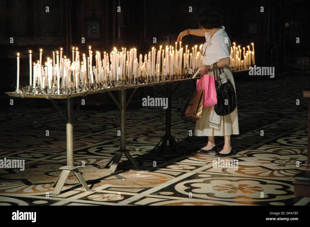 Milano, Italy a woman lighting a candle at the Duomo Stock Photo Alamy