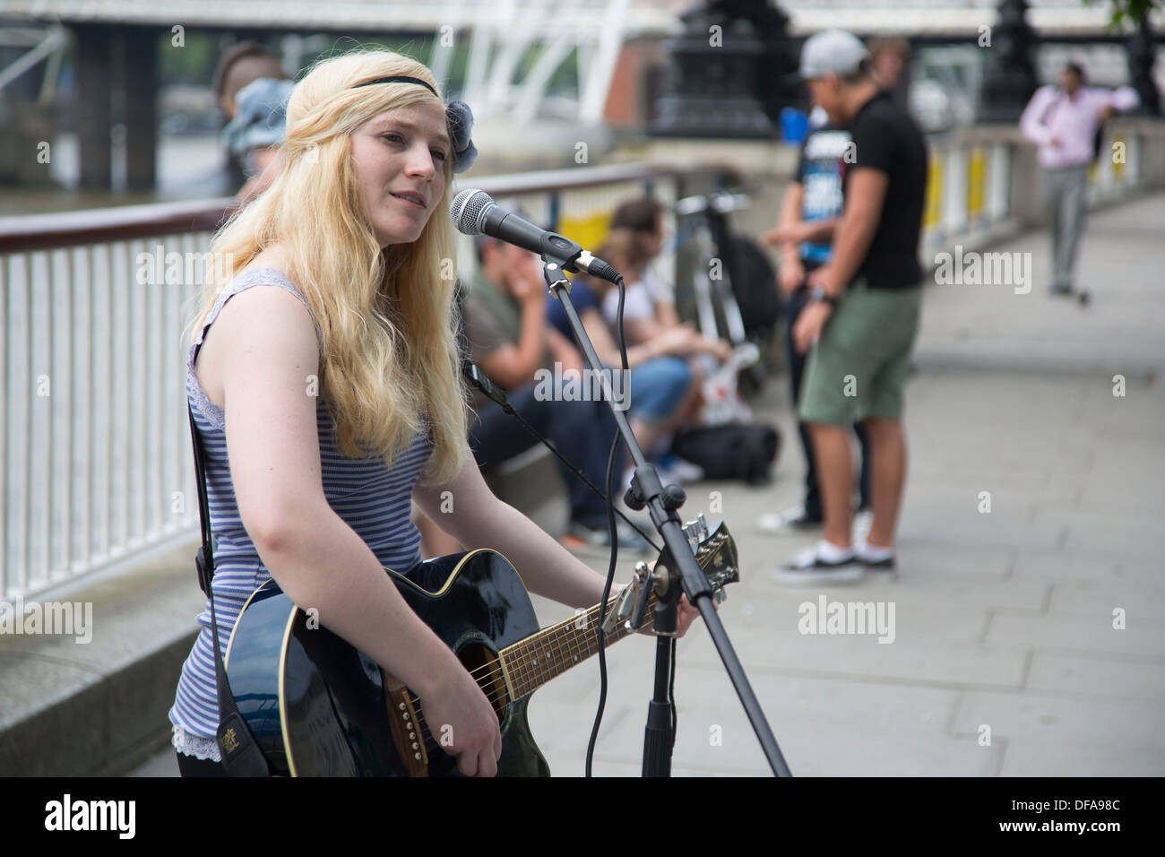 Young busker (Charlotte Campbell) performing her music, both singing