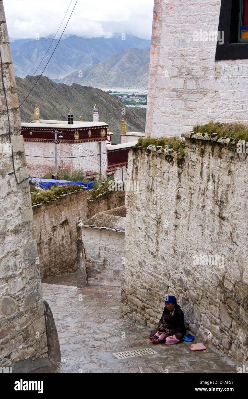 Tibetan mother with toddler begging, Drepung monastery, Lhasa, Tibet Stock Photo