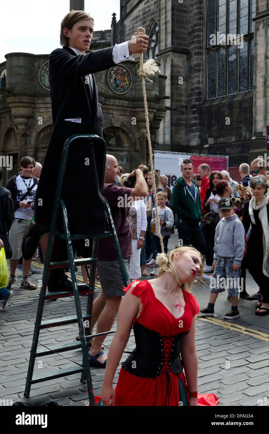 Theatre group promoting their show (woman being hung) during the Festival Fringe in the Royal Mile, Edinburgh, Scotland. Stock Photo