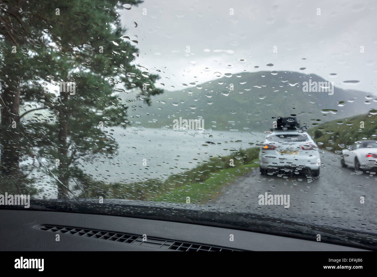 Cars parked beside a lake during a rain storm. Stock Photo