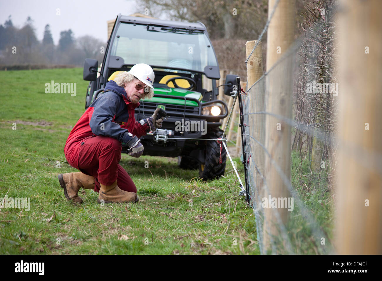 Using the winch on a John Deere Gator to tension a fence UK Stock Photo