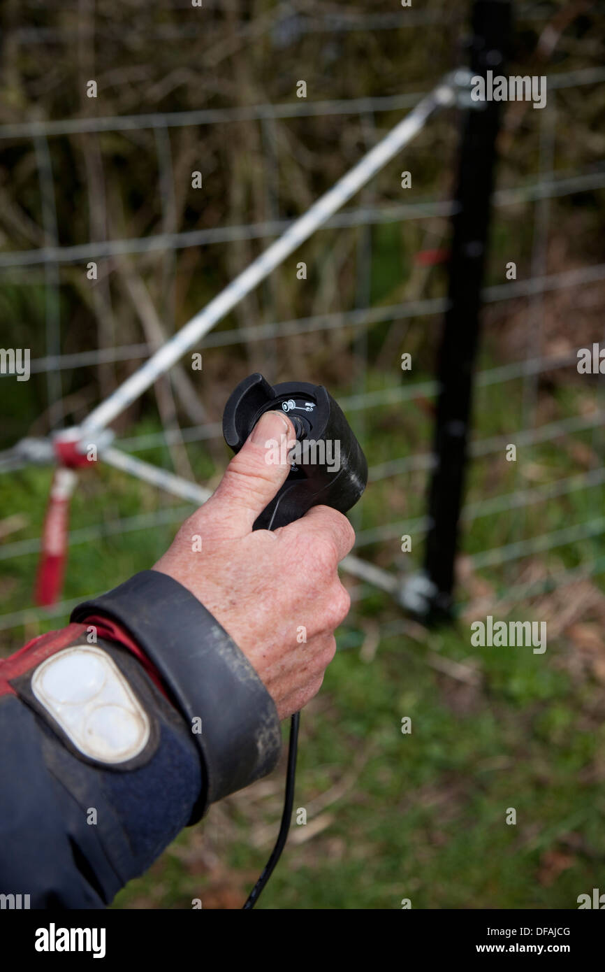 Using the winch on a John Deere Gator to tension a fence UK Stock Photo