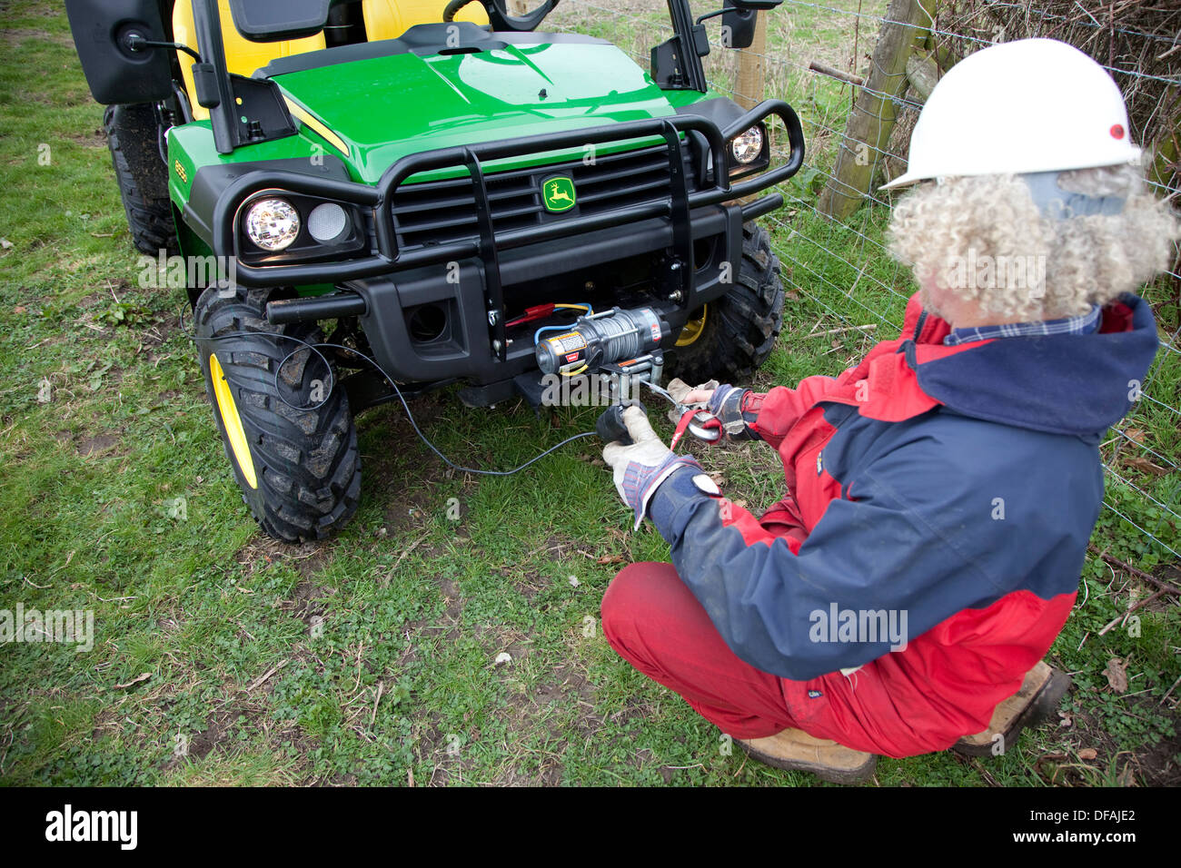 Using the winch on a John Deere Gator to tension a fence UK Stock Photo