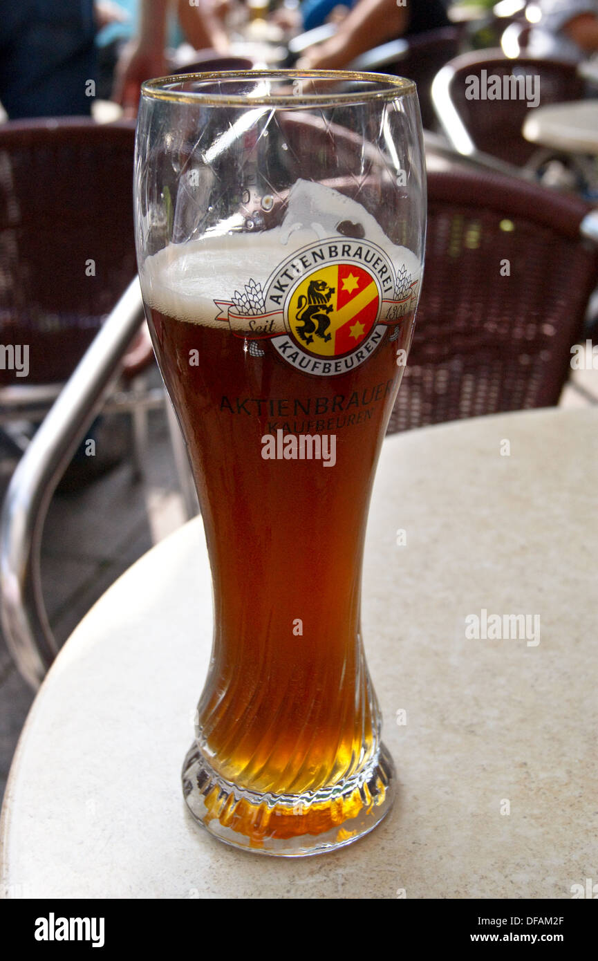 A printed glass of Kaufbeuren dunkles bier (dark beer) on a bar in Munich, Bavaria, Germany pub table drinks glasses Stock Photo