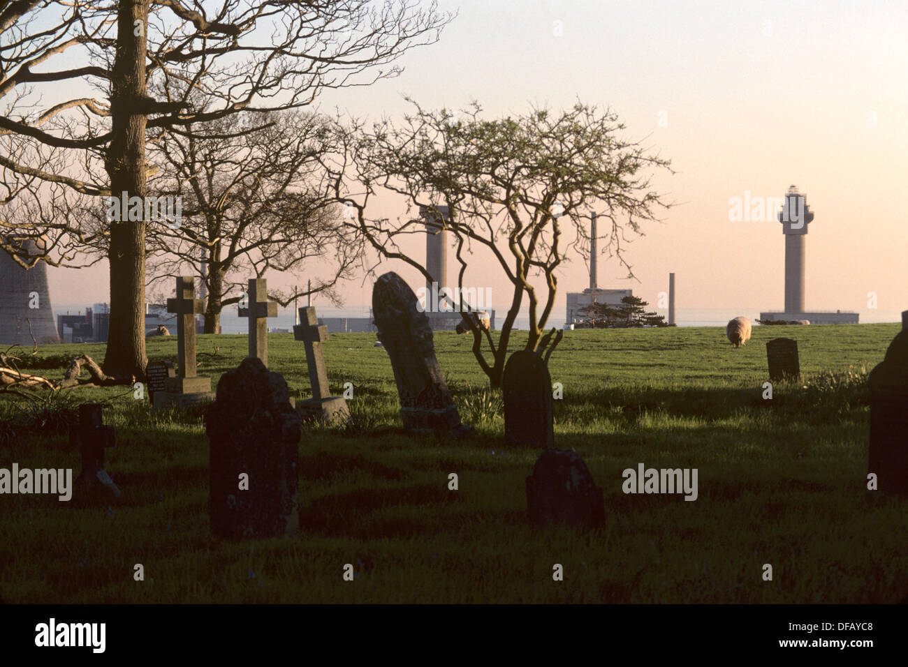 Seascale village graveyard with Sellafield nuclear reprocessing plant in the background. Cumbria, UK. Stock Photo
