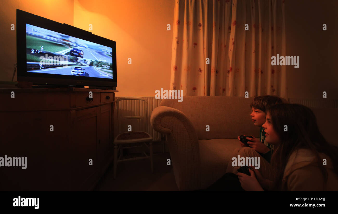 Boy and girl playing racing game on Xbox Stock Photo Alamy