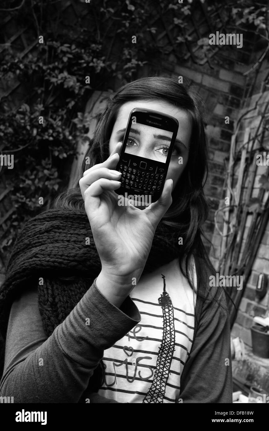 Girl holding blackberry phone up in front of her face Stock Photo