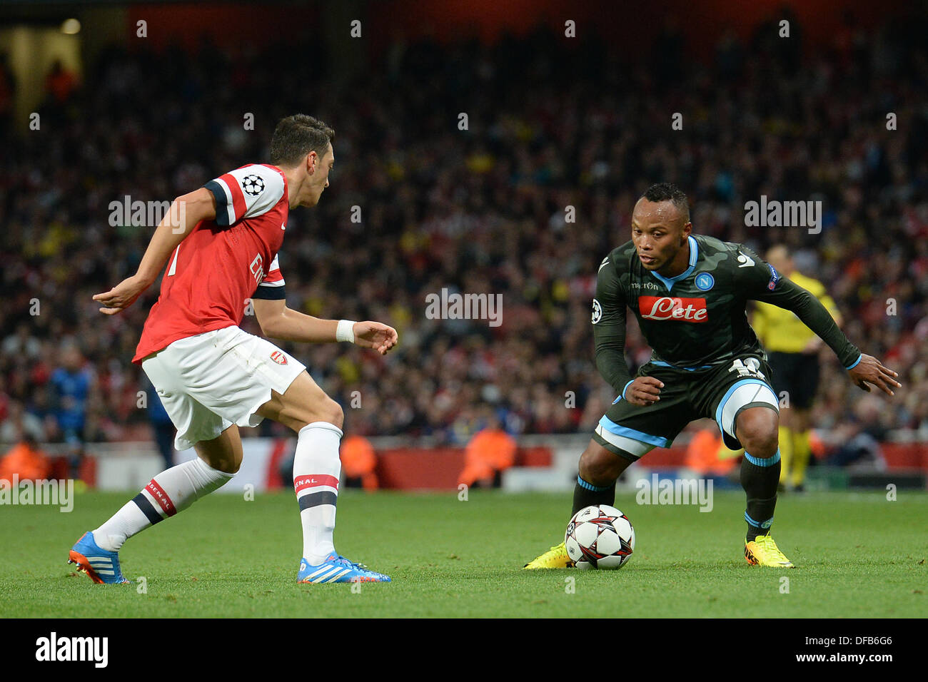 London, UK. 01st Oct, 2013. Arsenal's midfielder Mesut Ozil from Germany and Napoli's defender Camilo Zuniga from Columbia during the UEFA Champions League match between Arsenal from England and Napoli from Italy played at The Emirates Stadium, on October 01, 2013 in London, England. © Mitchell Gunn/ESPA/Alamy Live News Stock Photo