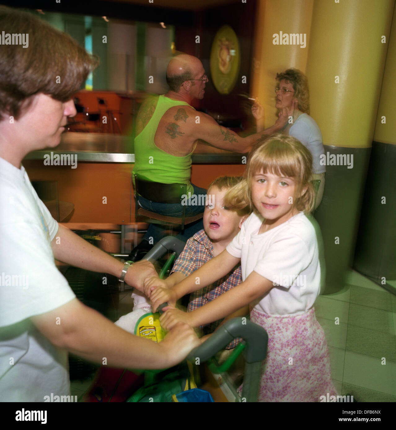 Two siblings ride on a baggage trolley at London Gatwick's terminal building Stock Photo Alamy