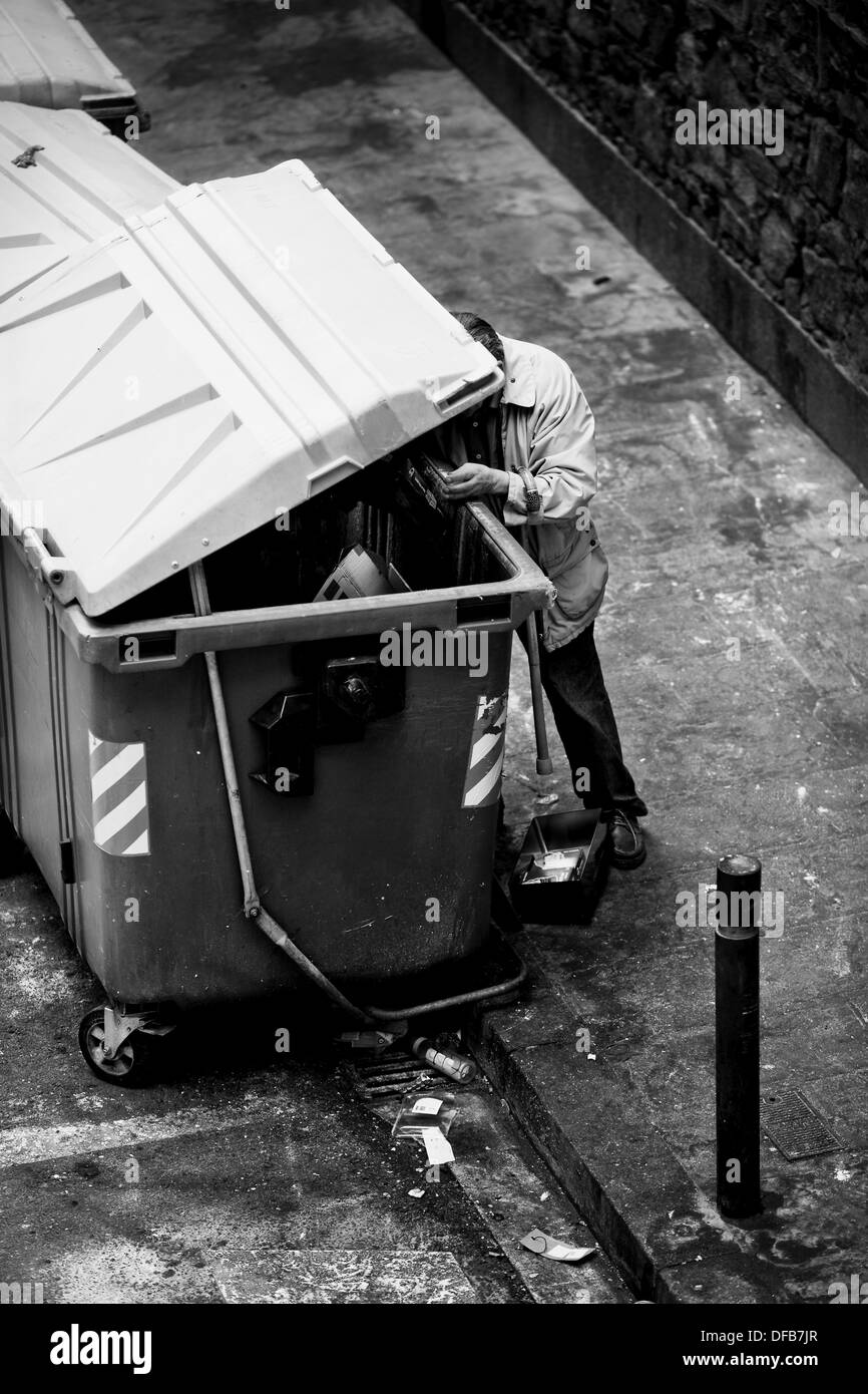 Man looking into a garbage container. Ciutat Vella. Barcelona. Spain