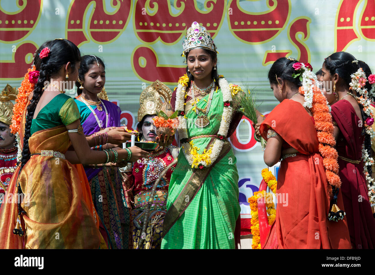 Indian girls in costumes offering aarti to girl dressed a goddess at a protest rally. Puttaparthi, Andhra Pradesh, India Stock Photo