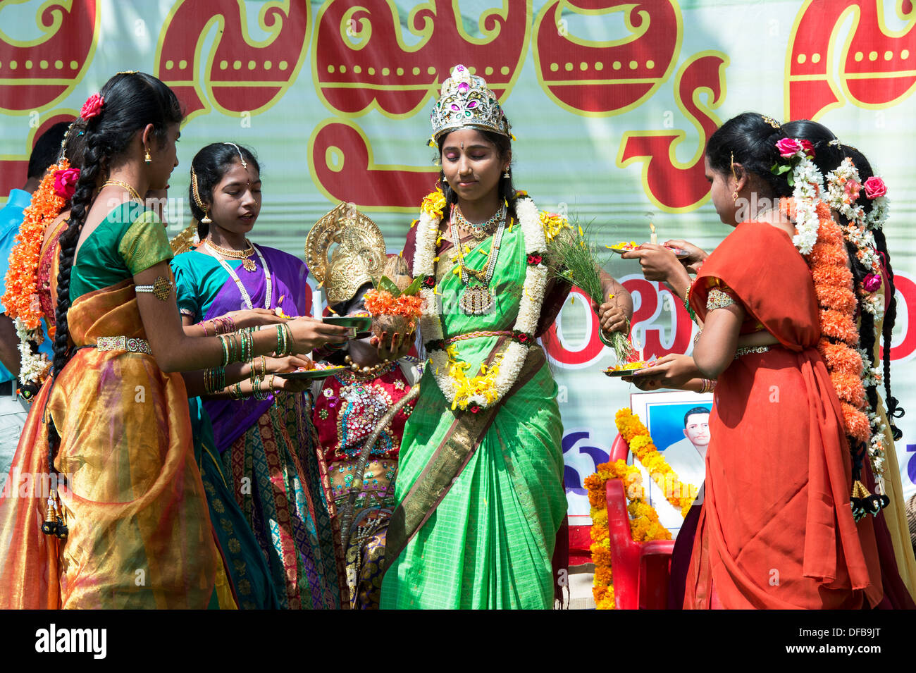 Indian girls in costumes offering aarti to girl dressed a goddess at a protest rally. Puttaparthi, Andhra Pradesh, India Stock Photo