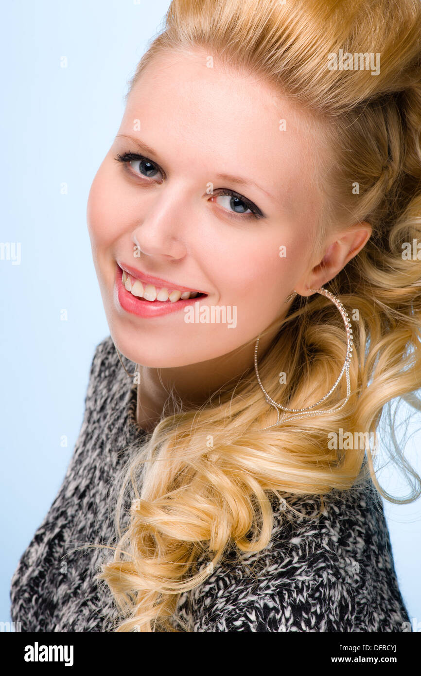 Portrait of smiling girl, blue background, vertical format Stock Photo
