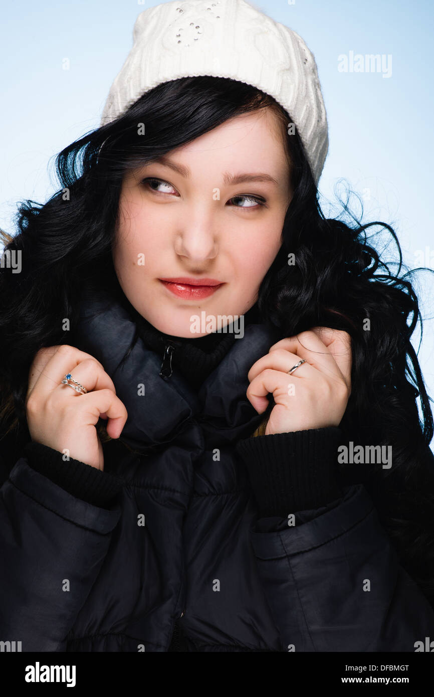 Beautiful girl wearing stocking cap, light blue background, vertical format Stock Photo