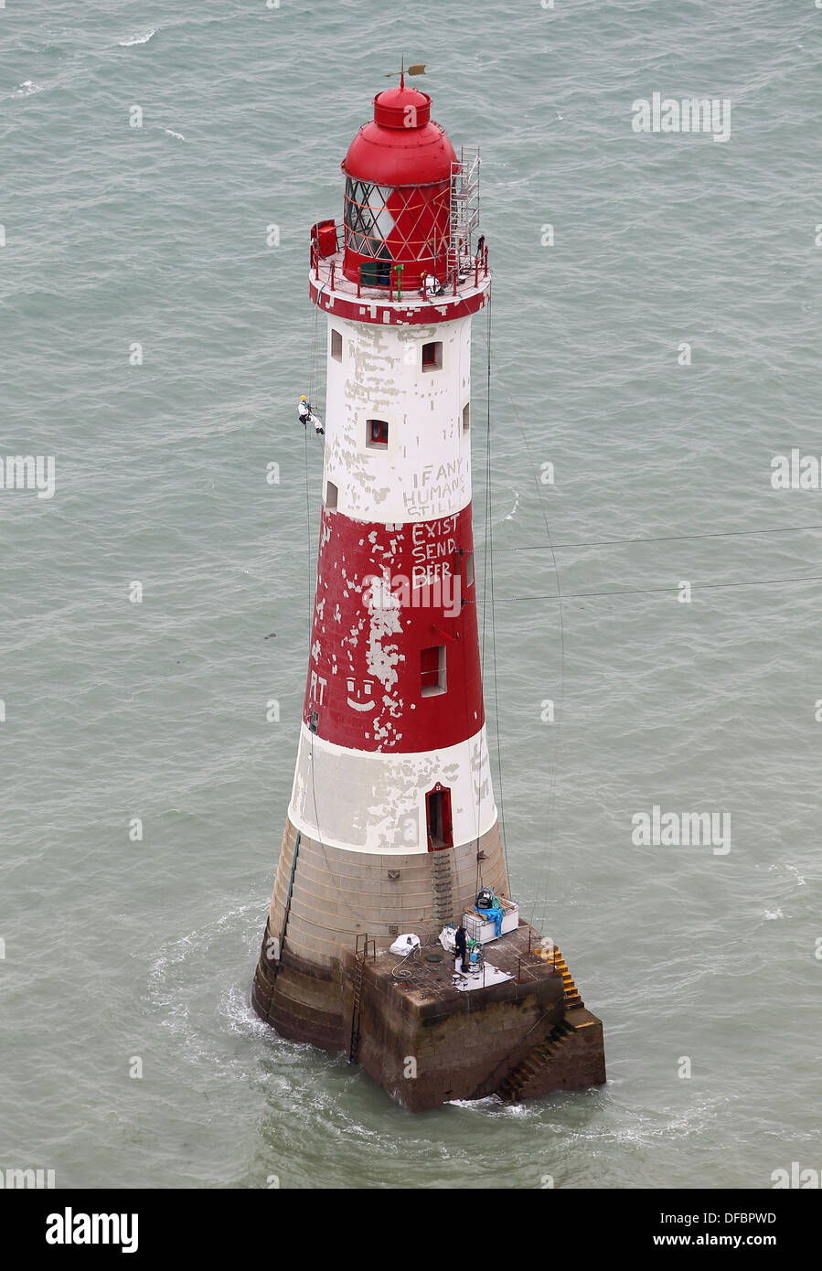 A painter works on repainting the stripes around the lighthouse at Beachy Head. Picture by James Boardman. Stock Photo