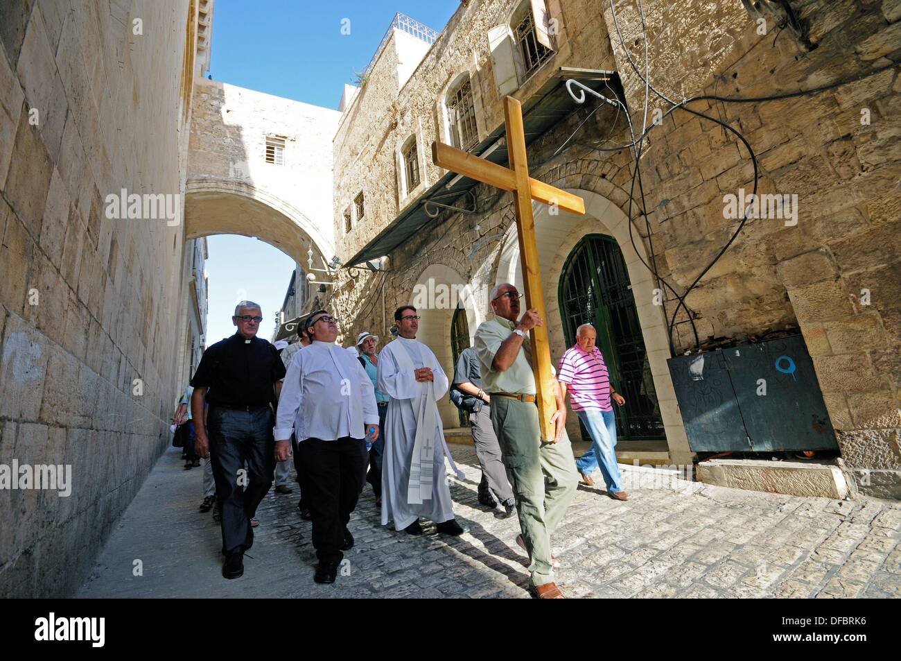 View of a procession of Christian pilgrims on the Via Dolorosa in Jerusalem, Israel, 12 September 2013. The Via Dolorosa (Way of Suffering) is a street in the old town of Jerusalem named after the path Jesus of Nazareth walked to his crucification. Jesus carried the cross, on which he later died via that road from the Antonia Fortress, then seat of Pilate, to Golgotha, the place where his grave is supposedly located. Above this place, the Church of the Holy Sepulchre was later built. The path led Jesus via 14 stations that are often visited by modern pilgrims walking through the old town. Phot Stock Photo