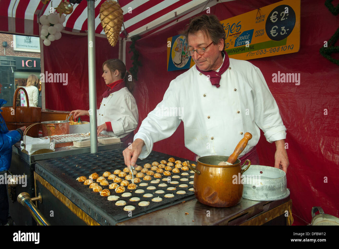Man bakes Poffertjes a Dutch pastry in a market stall in Amersfoort, Netherlands Stock Photo