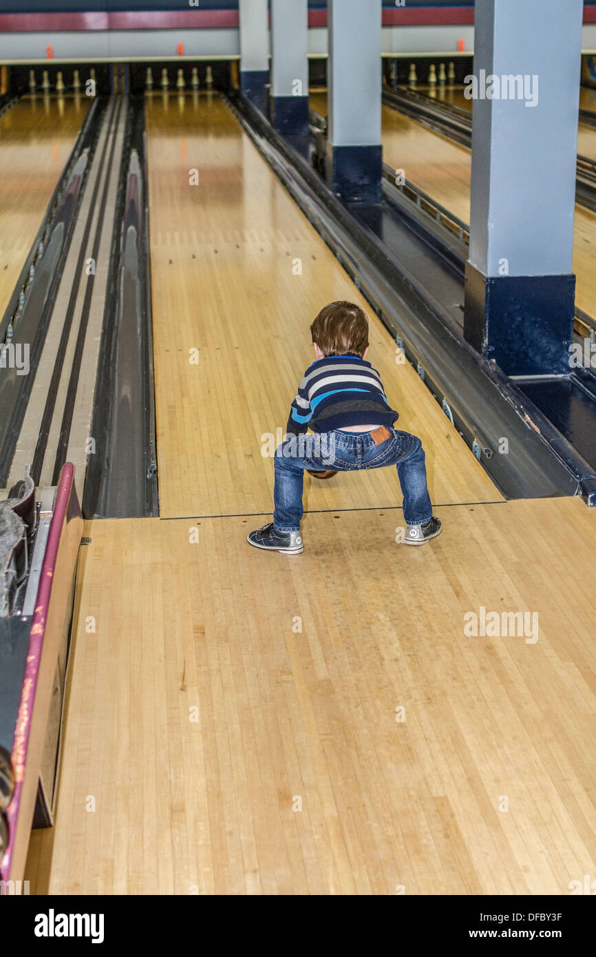 Model released three year old boy, enjoying a game of bowling, a fun activity. Stock Photo