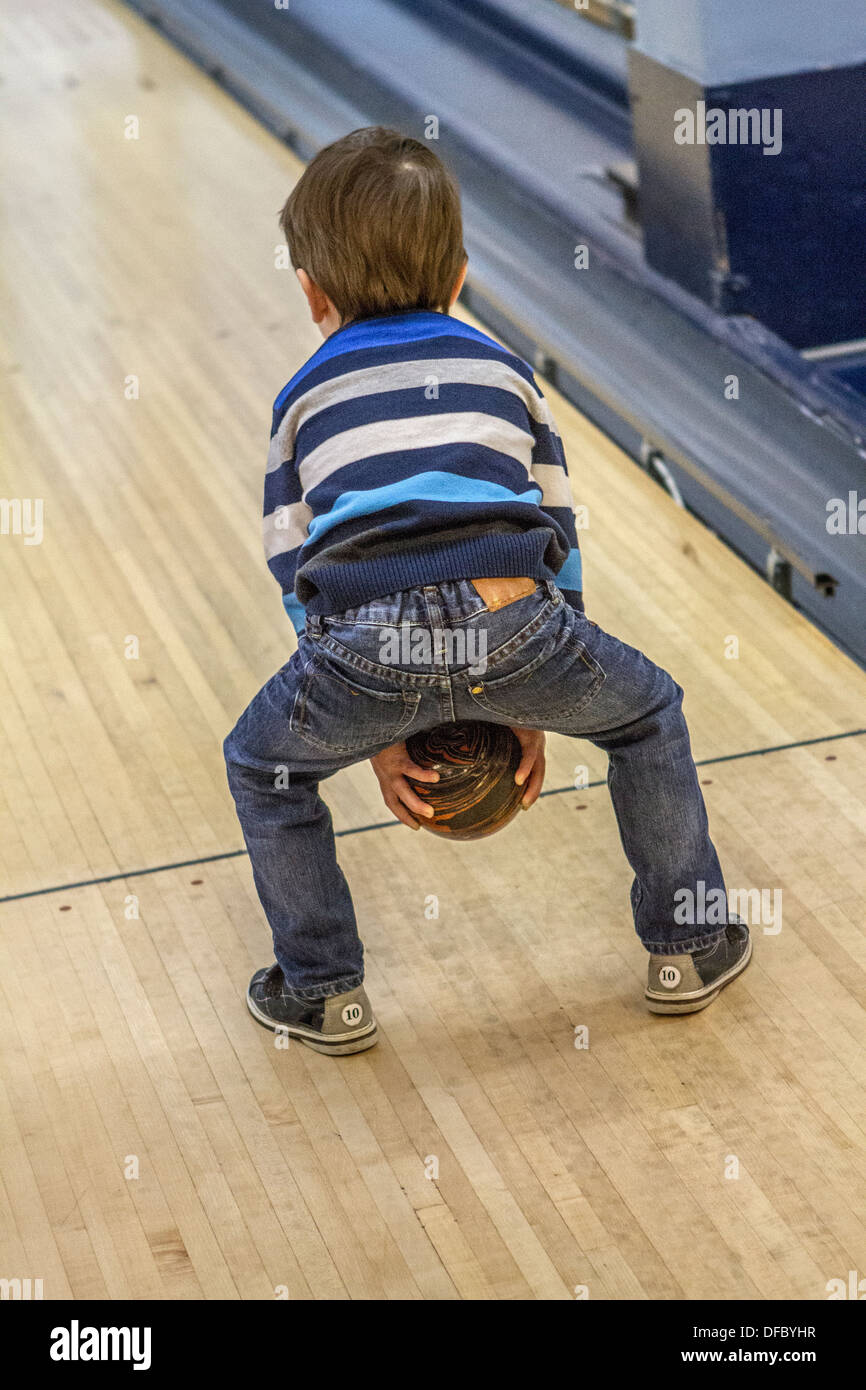 Model released three year old boy, enjoying a game of bowling, a fun activity. Stock Photo