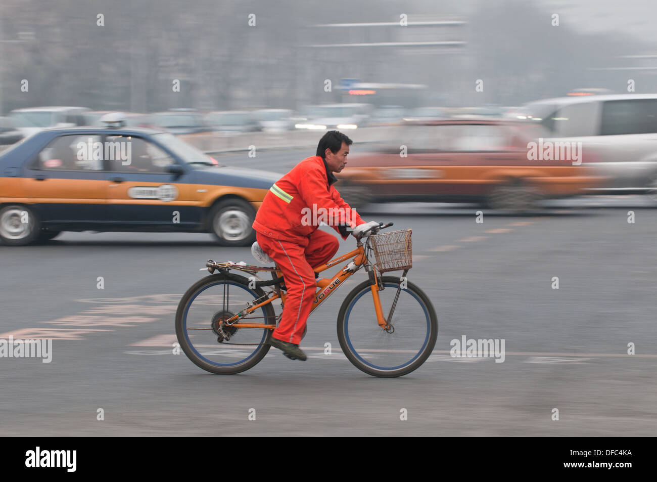 Chinese worker on bike in Beijing, China Stock Photo