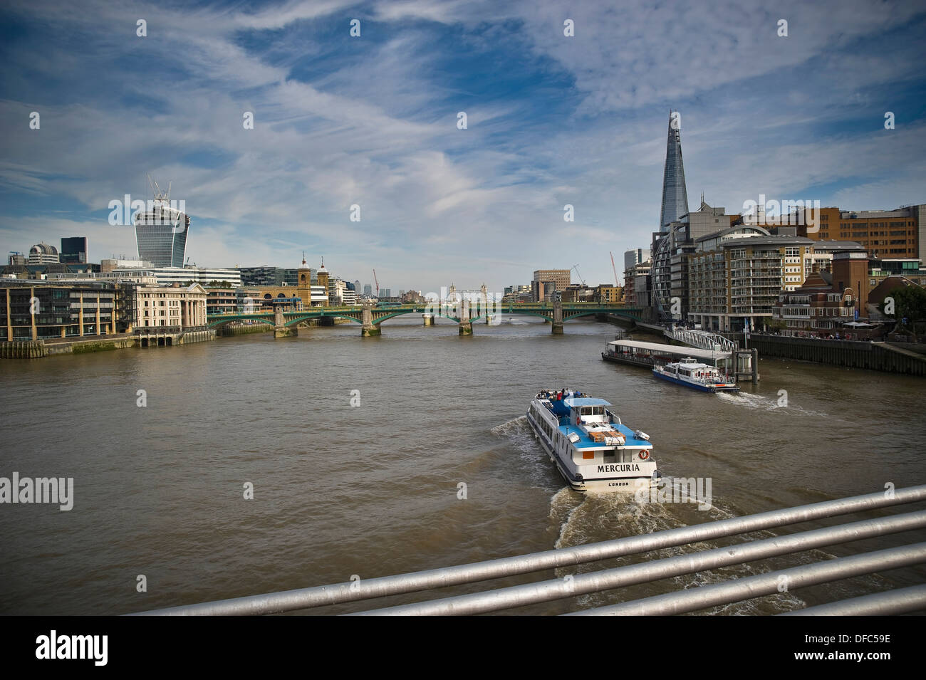 Thames Clipper passing under the Millennium Bridge on the River Thames, London, UK Stock Photo