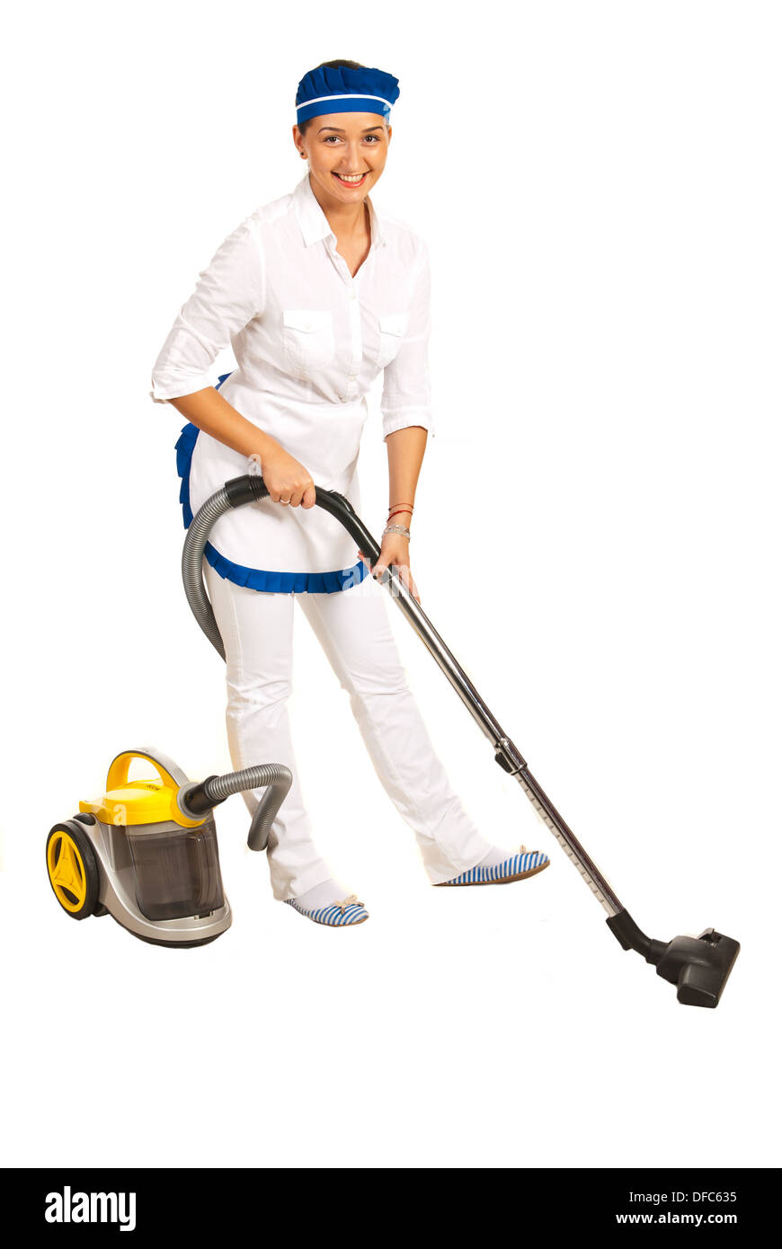 Maid in uniform using vacuum cleaner to clean the room against white