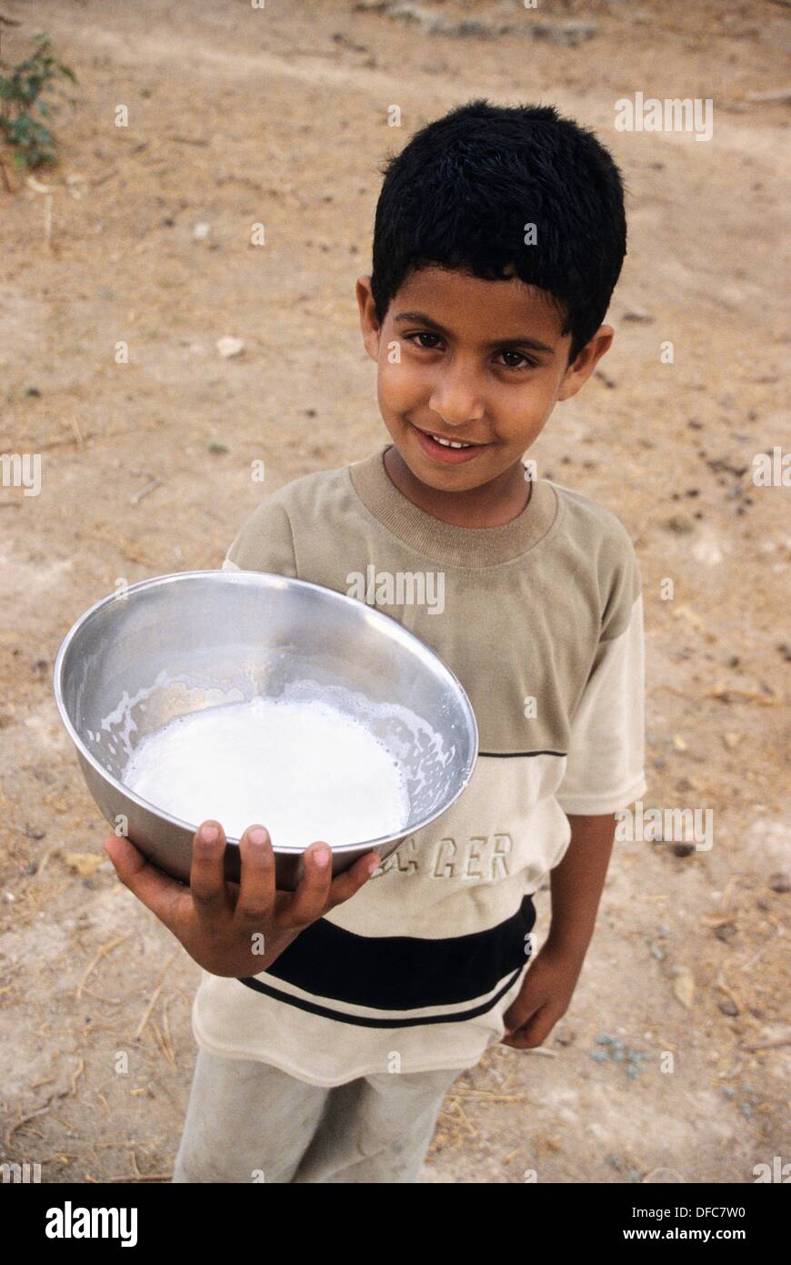 young bedouin boy holding a bowl of fresh camel milk,Dhofar,Sultanate