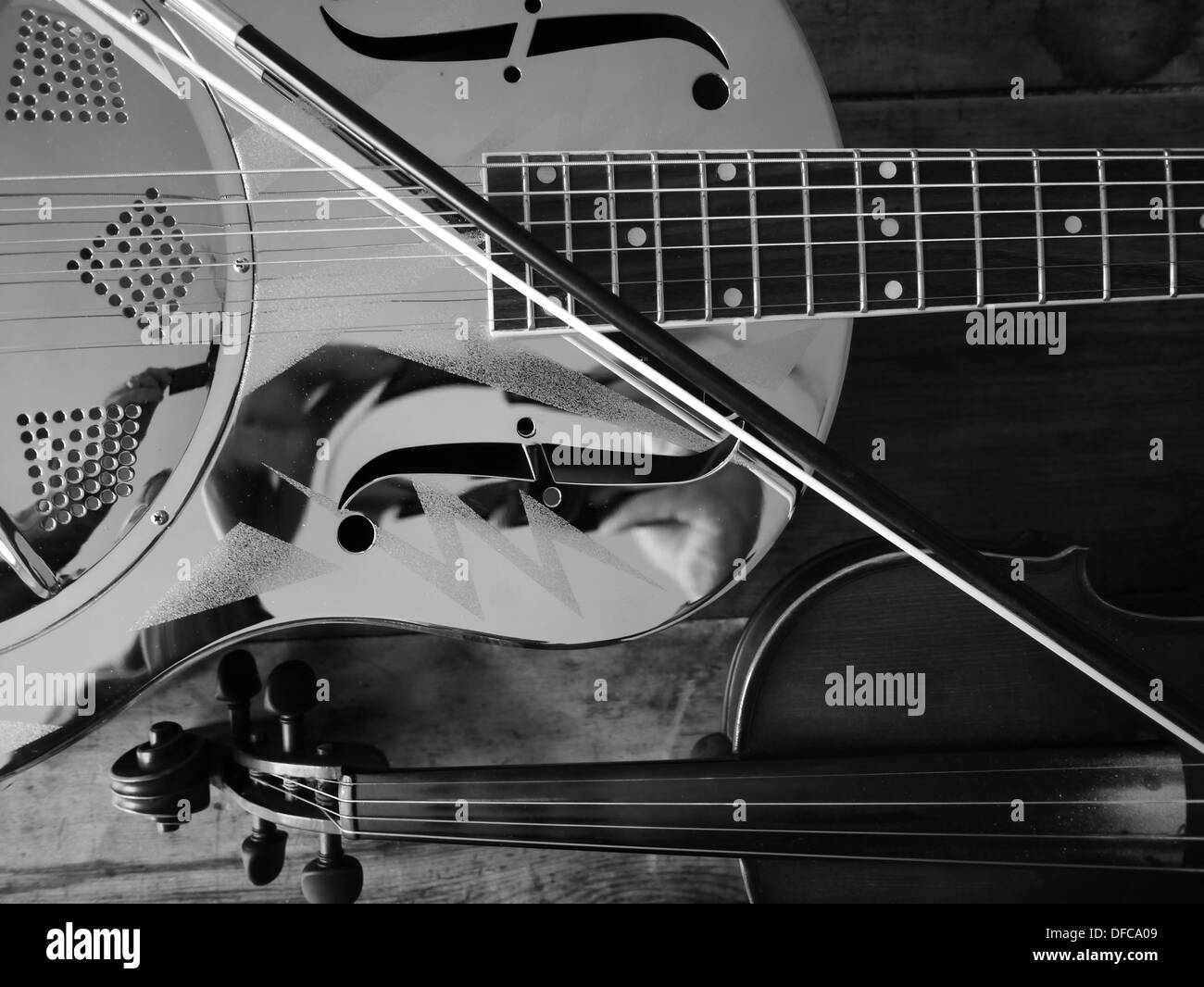 A resonating guitar and a violin/fiddle laying across each other Stock ...