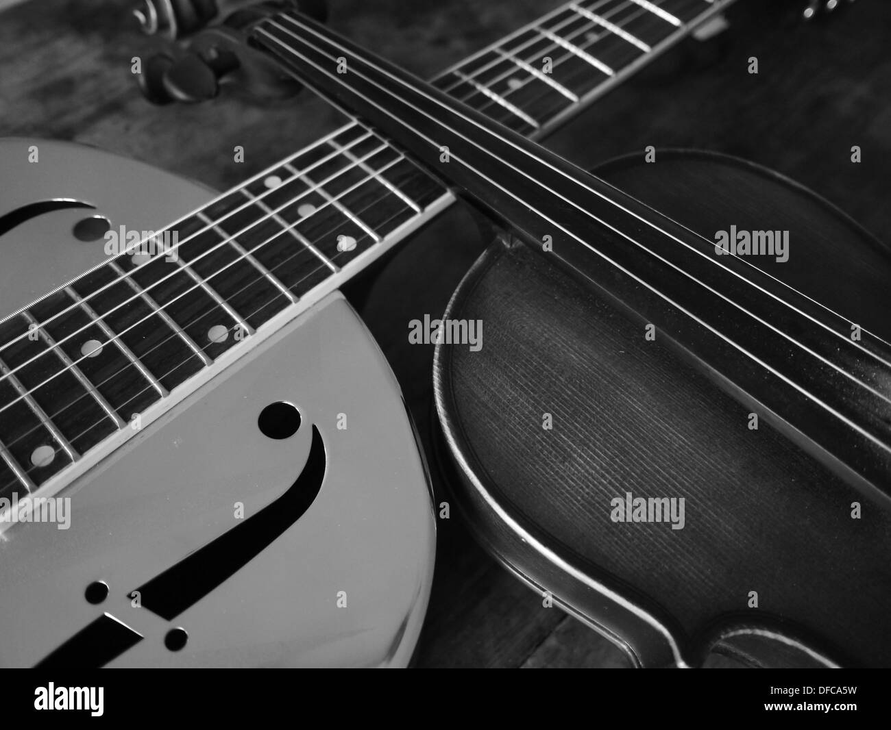 A resonating guitar and a violin/fiddle laying across each other Stock ...