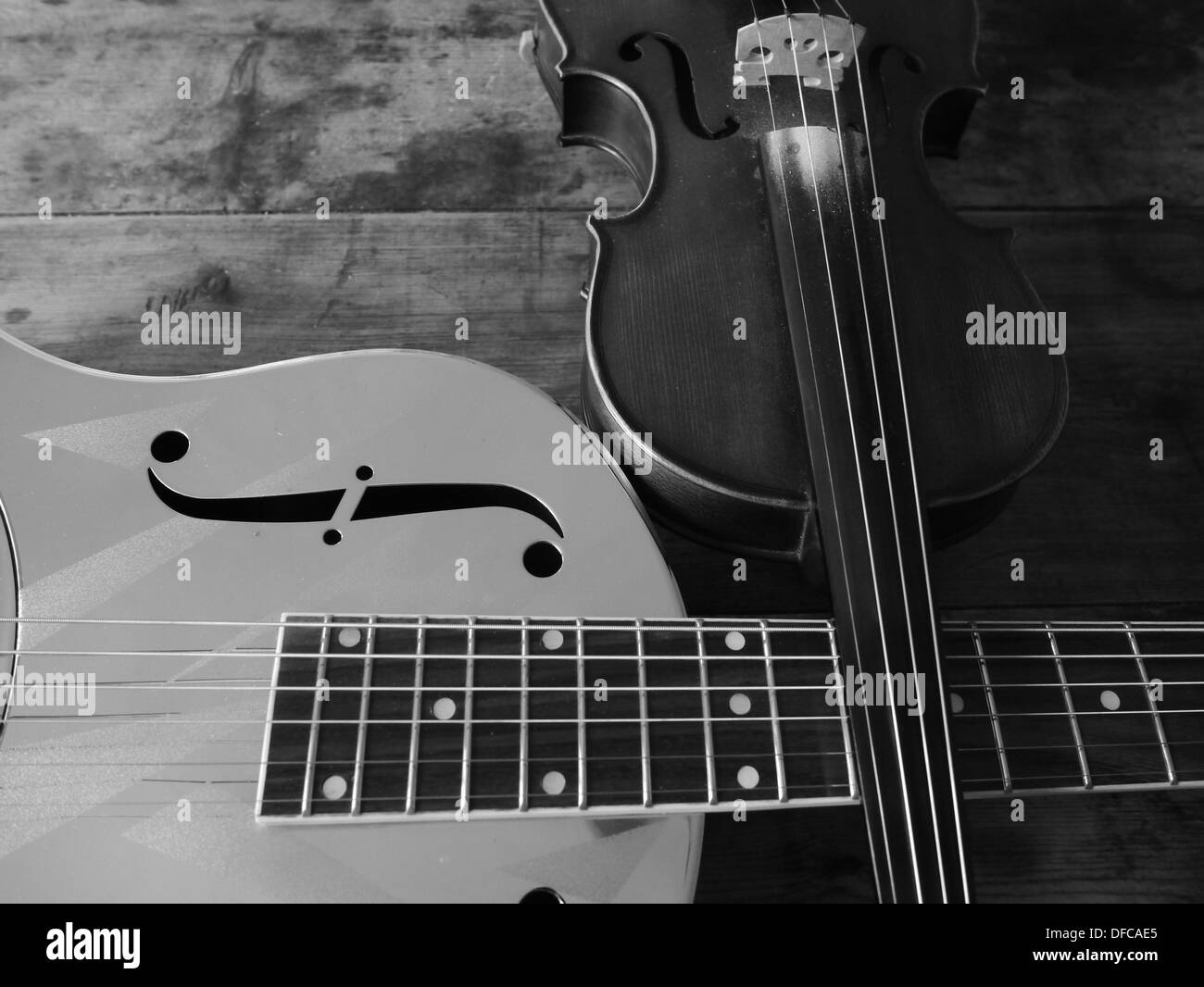 A resonating guitar and a violin/fiddle laying across each other Stock ...