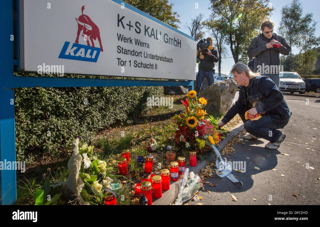 The miners Hans-Dieter Hartung and Danny Freißmann (R) lay down flowers at the shaft II of the K+S plant Werra near Unterbreizbach, Germany, 01 October 2013. After the mining disaster in a potash mine of the K+S Kali GmbH with three dead, the prosecution looks for the cause of the accident. Photo: MICHAEL REICHEL/dpa Stock Photo