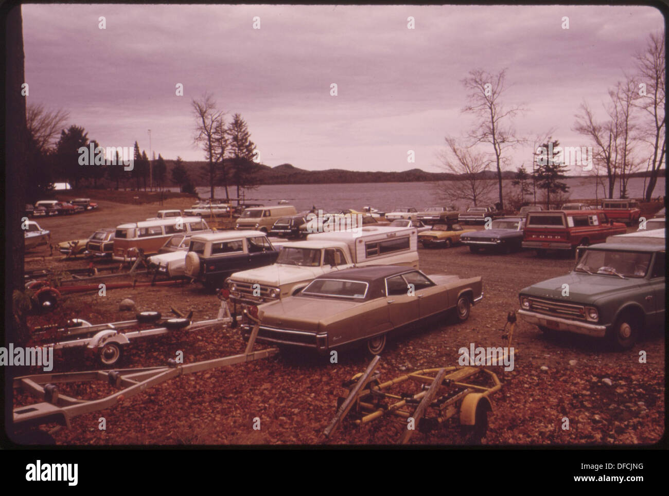 CARS, PICKUP TRUCKS AND EMPTY BOAT TRAILERS FILL A PARKING LOT AT THE